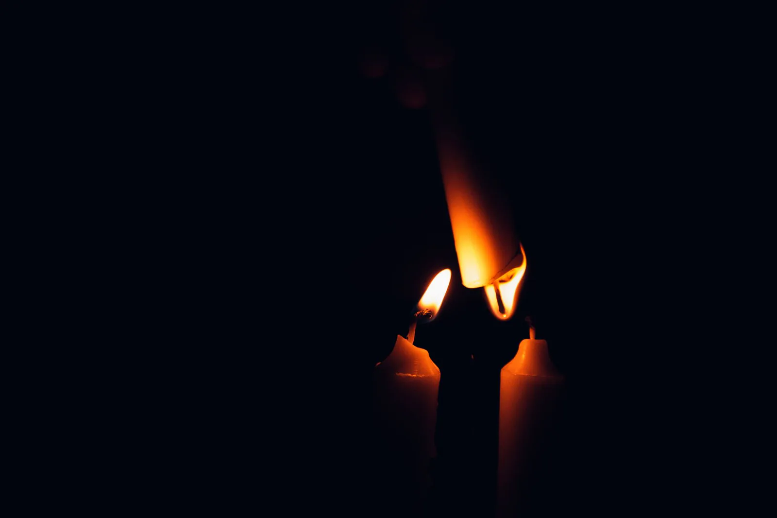 Close-up of candle flames against dark background
